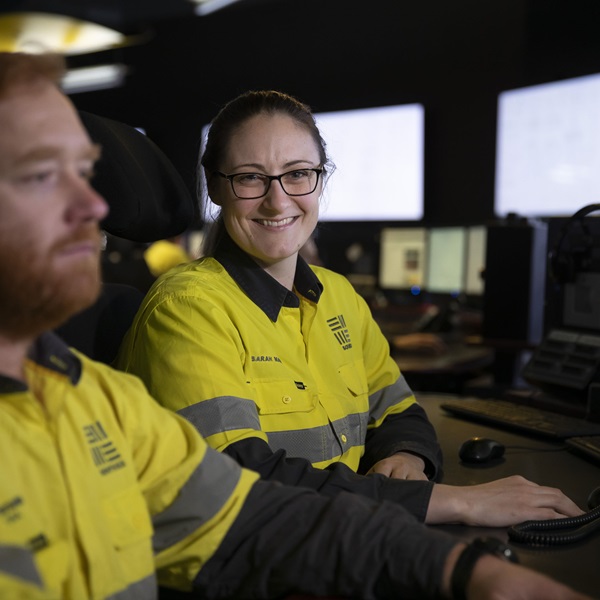 Two workers sitting near computers in a control room at Worsley