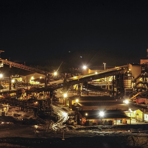 A photo of the GEMCO facility at night, showing conveyer belts and a number of buildings