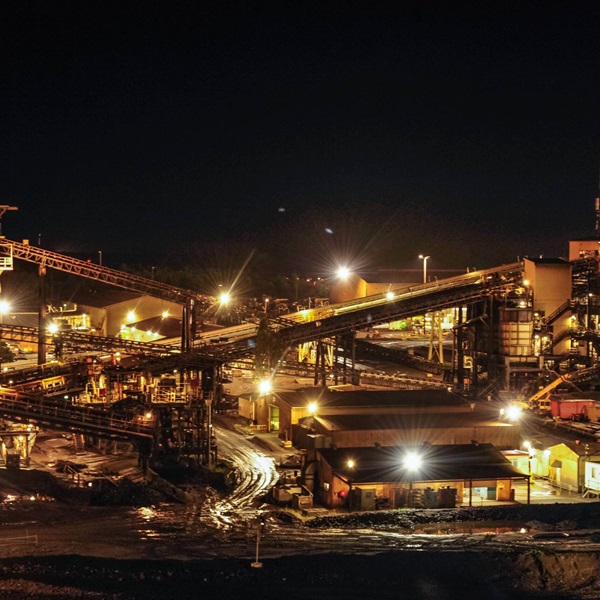 A photo of the GEMCO facility at night, showing conveyer belts and a number of buildings