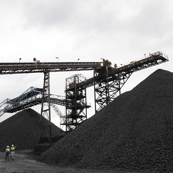 A photo of machinery and a large pile of manganese at Hotazel Manganese Mines.