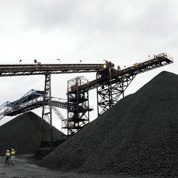 A photo of machinery and a large pile of manganese at Hotazel Manganese Mines.